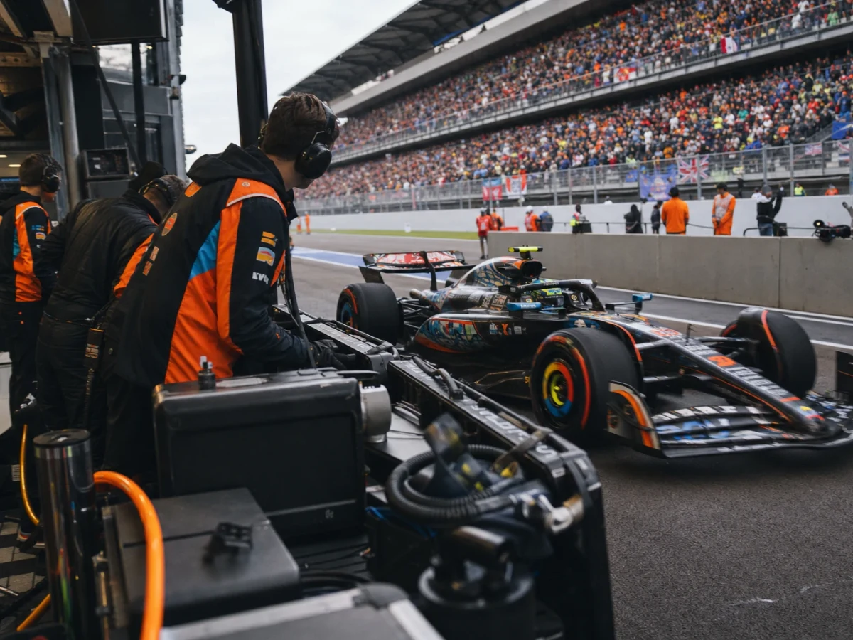 Två formel 1-bilar sida vid sida på en lång raksträcka i hög fart.